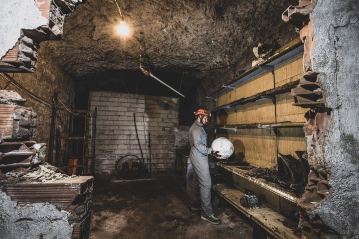 a man standing in front of a stone building