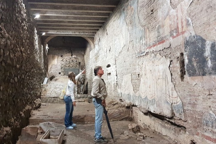 a man wearing a stone building that has a rock wall