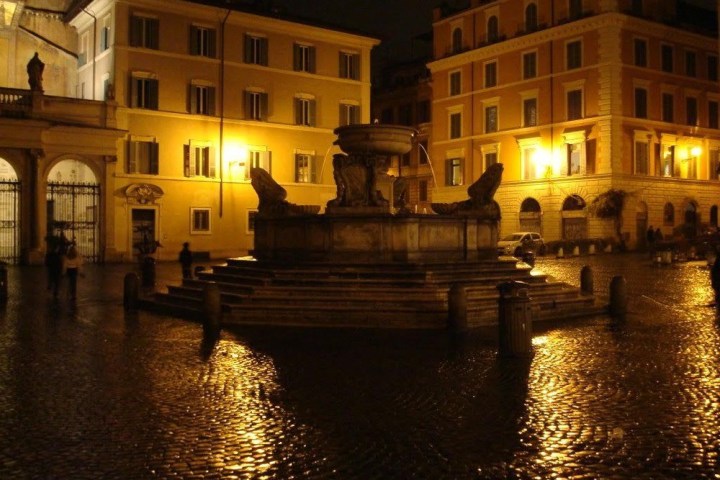 a building next to a body of water with a city in the background