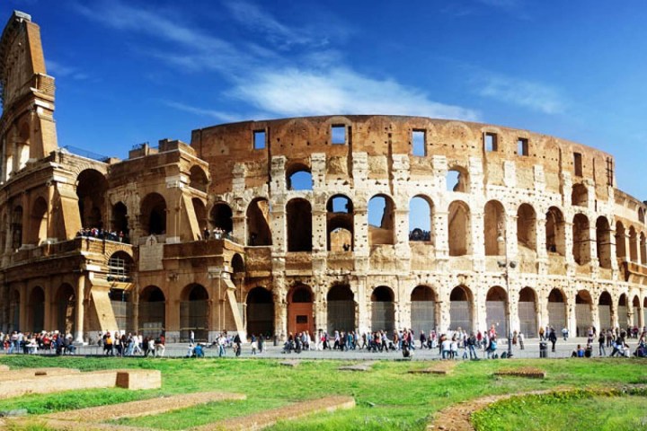 a large stone building with Colosseum in the background